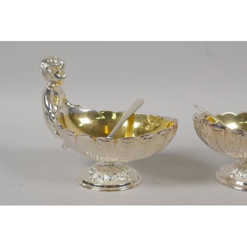 645 - A pair of silver plated clam shaped salts with putti decoration, 10cm high