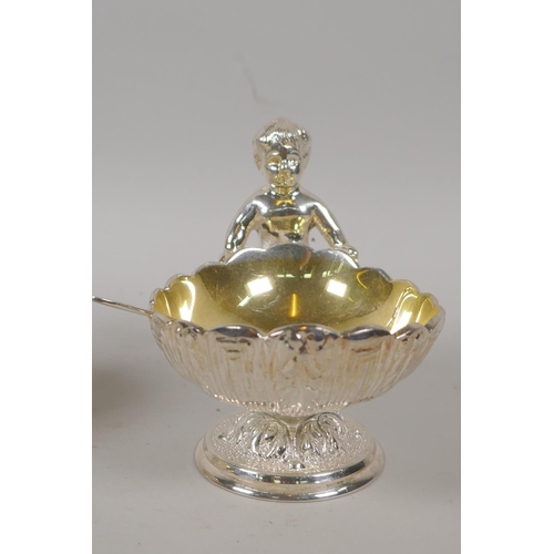 645 - A pair of silver plated clam shaped salts with putti decoration, 10cm high