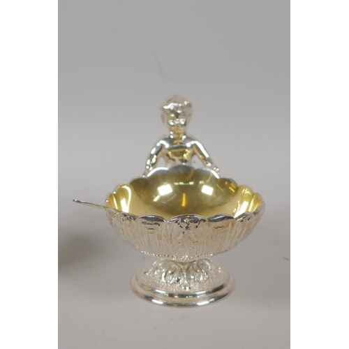 645 - A pair of silver plated clam shaped salts with putti decoration, 10cm high