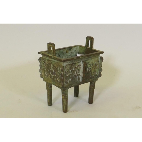 68 - Chinese bronze censer with two handles and archaic style decoration, raised on four supports, 15cm h... 