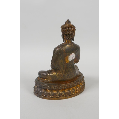 75 - A Tibetan gilt bronze figure of Buddha seated on a lotus throne, double vajra mark to base, 15cm hig... 