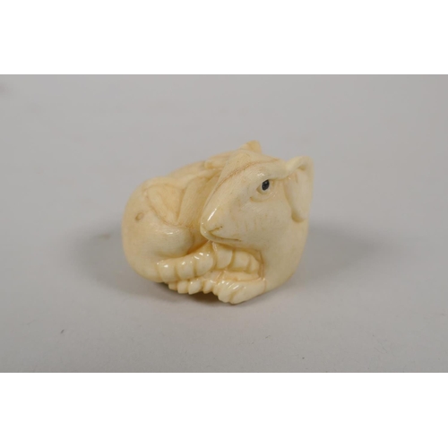 82 - A Japanese carved bone rat netsuke, signed to base, and a carved boxwood inro decorated with rabbits... 