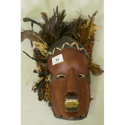 84 - An African tribal mask painted wood with applied feathers and woven basket headdress, Lwalwa tribe, ... 