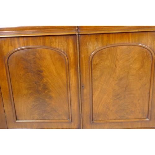 1134 - A Victorian mahogany bookcase with two arched glazed doors over two frieze drawers and cupboards, ra... 