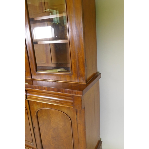 1134 - A Victorian mahogany bookcase with two arched glazed doors over two frieze drawers and cupboards, ra... 