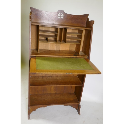 1178 - An Arts & Crafts oak hall/student's bureau, the fall front with fitted interior over two open sh... 