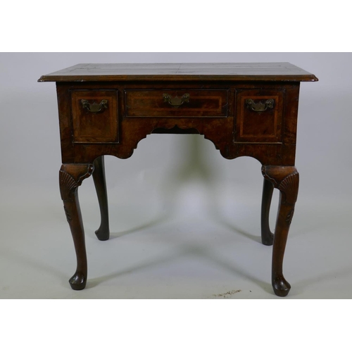 1001 - A Georgian walnut lowboy, the quarter veneered top with moulded edge and cut corners with herringbon... 