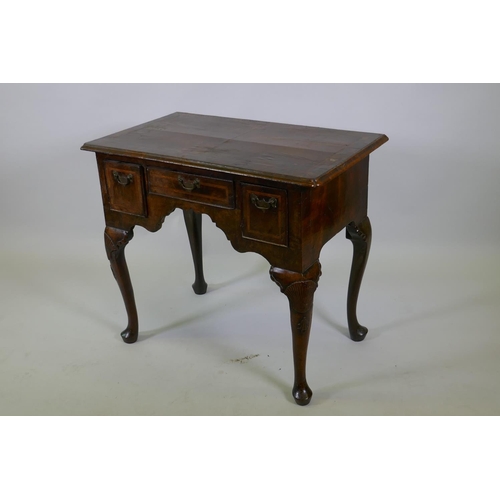 1001 - A Georgian walnut lowboy, the quarter veneered top with moulded edge and cut corners with herringbon... 