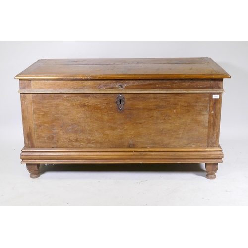 1006 - A C19th Dutch colonial padouk wood coffer, the interior fitted with a candle box, raised on turned f... 