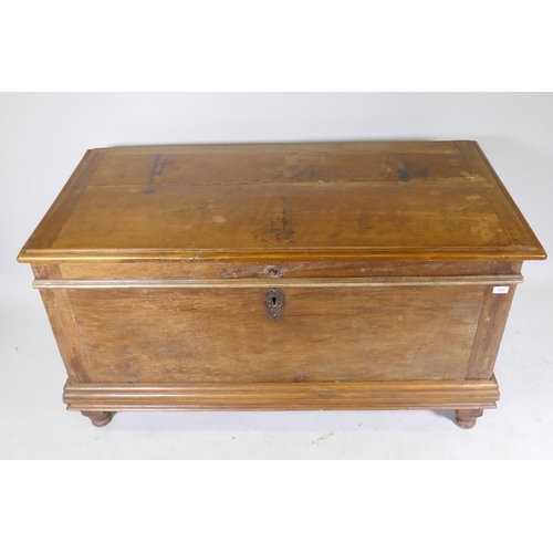 1006 - A C19th Dutch colonial padouk wood coffer, the interior fitted with a candle box, raised on turned f... 