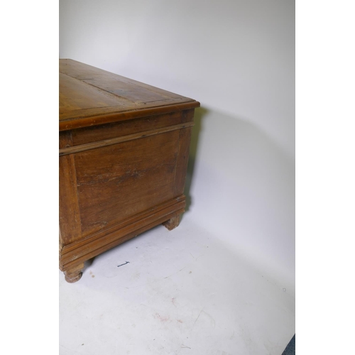 1006 - A C19th Dutch colonial padouk wood coffer, the interior fitted with a candle box, raised on turned f... 