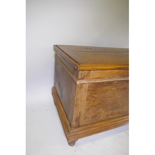 1006 - A C19th Dutch colonial padouk wood coffer, the interior fitted with a candle box, raised on turned f... 