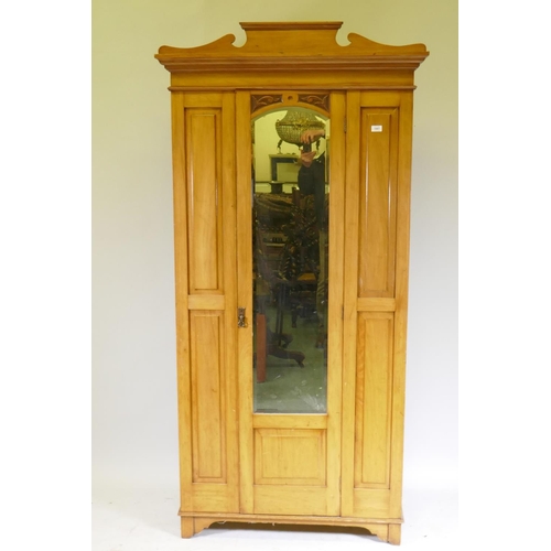 1007 - A Victorian satin-walnut wardrobe with single mirrored door, shaped pediment and carved decoration, ... 