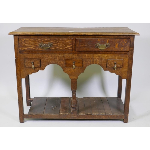 1013 - An oak side table with two long and three short drawers, and shaped apron with planked undertier, 92... 