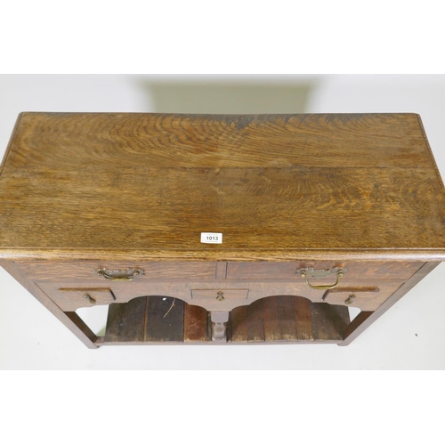 1013 - An oak side table with two long and three short drawers, and shaped apron with planked undertier, 92... 