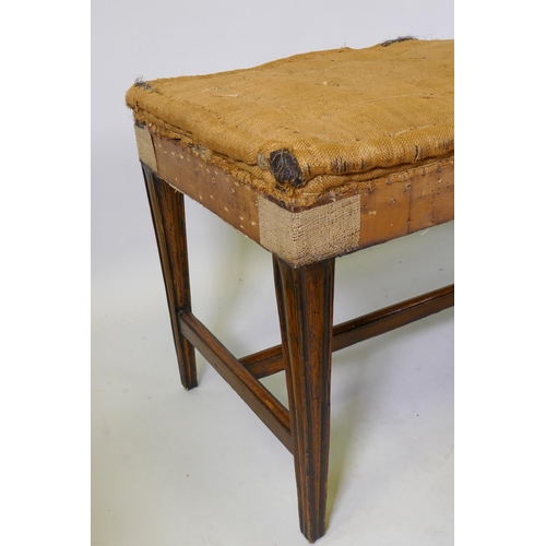 1023 - A pair of C19th oak country house window seats, raised on moulded tapering supports, united by H str... 