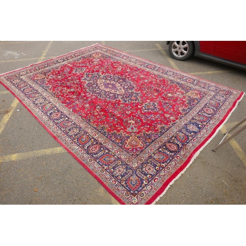 1024 - A large red ground Meshed carpet, with central medallion design and floral borders, circa C20th, 400... 