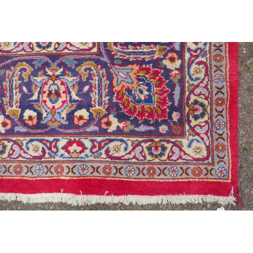 1024 - A large red ground Meshed carpet, with central medallion design and floral borders, circa C20th, 400... 