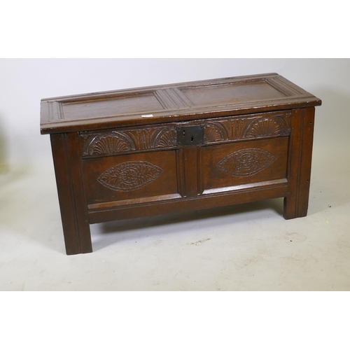 1035 - An C18th oak two panel coffer with hinged top, carved frieze and front panels, raised on stile suppo... 