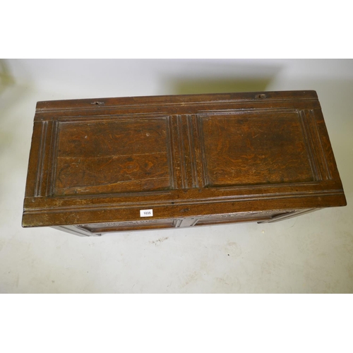 1035 - An C18th oak two panel coffer with hinged top, carved frieze and front panels, raised on stile suppo... 