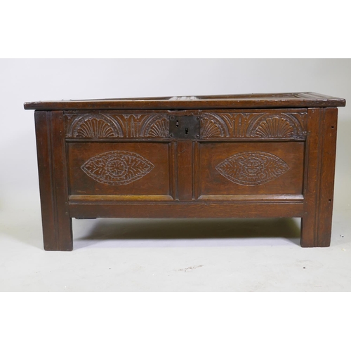 1035 - An C18th oak two panel coffer with hinged top, carved frieze and front panels, raised on stile suppo... 