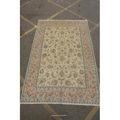 1040 - A cream ground Isfahan carpet with an all over floral design and blue borders, 180 x 240cm