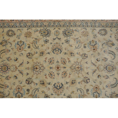 1040 - A cream ground Isfahan carpet with an all over floral design and blue borders, 180 x 240cm