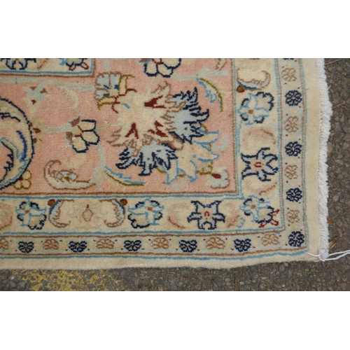 1040 - A cream ground Isfahan carpet with an all over floral design and blue borders, 180 x 240cm