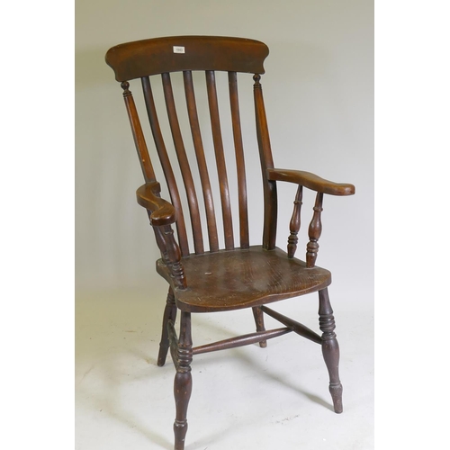 1043 - A Victorian Windsor elbow chair with lathe back scroll end arms and elm seat, raised on turned suppo... 