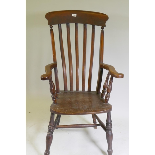 1043 - A Victorian Windsor elbow chair with lathe back scroll end arms and elm seat, raised on turned suppo... 