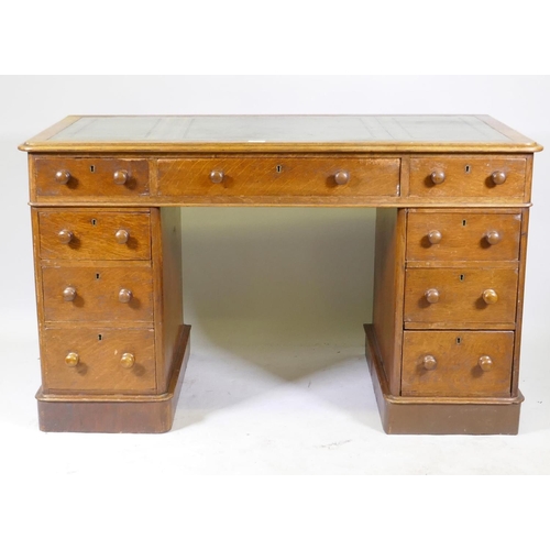 1052 - Victorian oak veneered nine drawer pedestal desk with gilt tooled leather inset top, 122 x 60 x 72cm