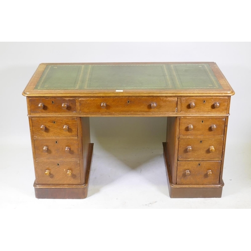 1052 - Victorian oak veneered nine drawer pedestal desk with gilt tooled leather inset top, 122 x 60 x 72cm