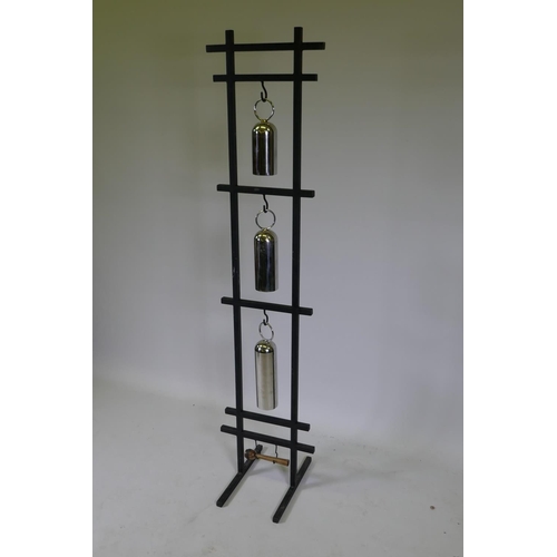 1053 - A graduated set of chromed metal gongs on a stand, 153cm high