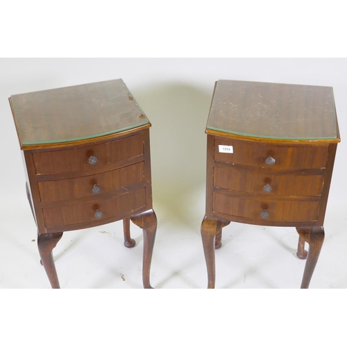 1054 - A pair of bowfront mahogany bedside chests with three drawers, raised on cabriole supports, 32cm dee... 