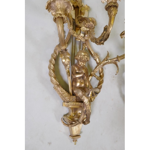 1056 - A pair of ormolu three branch Rococo style wall sconces with putti, oak leaf and swag decoration, 98... 