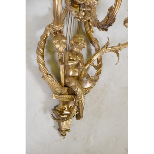 1056 - A pair of ormolu three branch Rococo style wall sconces with putti, oak leaf and swag decoration, 98... 