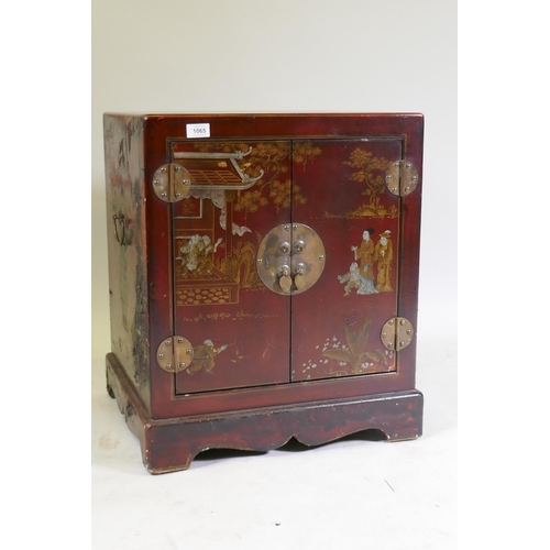 1065 - A chinoiserie red lacquer chest with brass mounts and handles, decorated with figures in a temple, 5... 