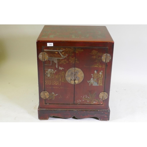 1065 - A chinoiserie red lacquer chest with brass mounts and handles, decorated with figures in a temple, 5... 