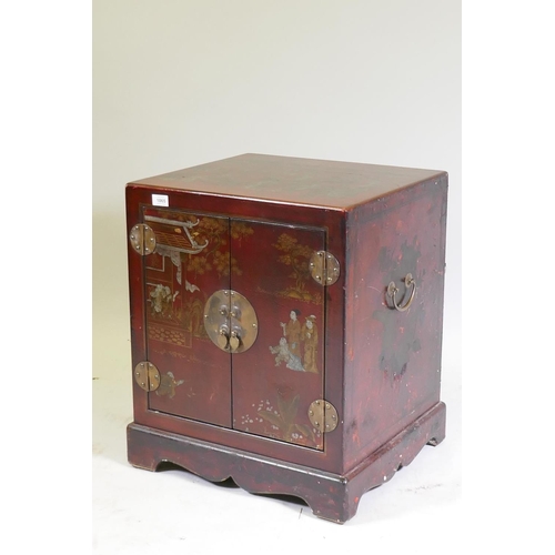 1065 - A chinoiserie red lacquer chest with brass mounts and handles, decorated with figures in a temple, 5... 