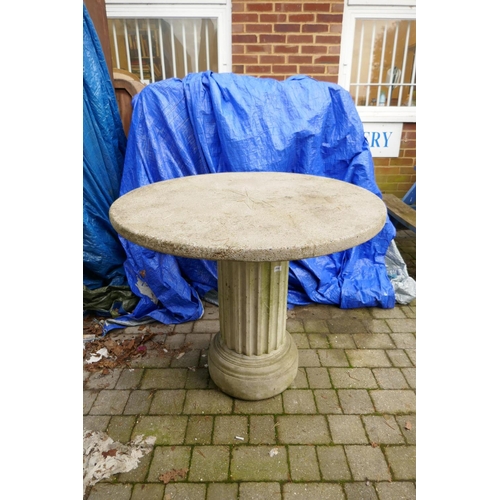 1066 - A reconstituted stone/concrete garden table on fluted column support, 103cm diameter, 84cm high