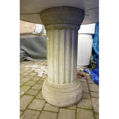 1066 - A reconstituted stone/concrete garden table on fluted column support, 103cm diameter, 84cm high