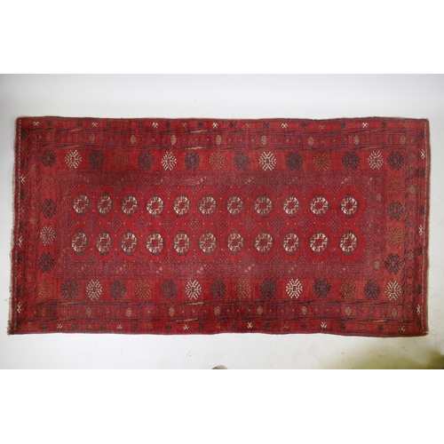 1075 - A Turkish red ground wool Bokhara rug, 102 x 190cm