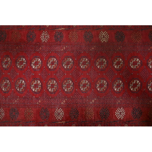 1075 - A Turkish red ground wool Bokhara rug, 102 x 190cm