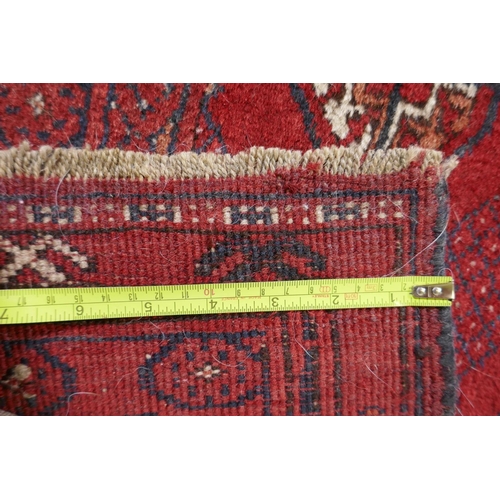 1075 - A Turkish red ground wool Bokhara rug, 102 x 190cm