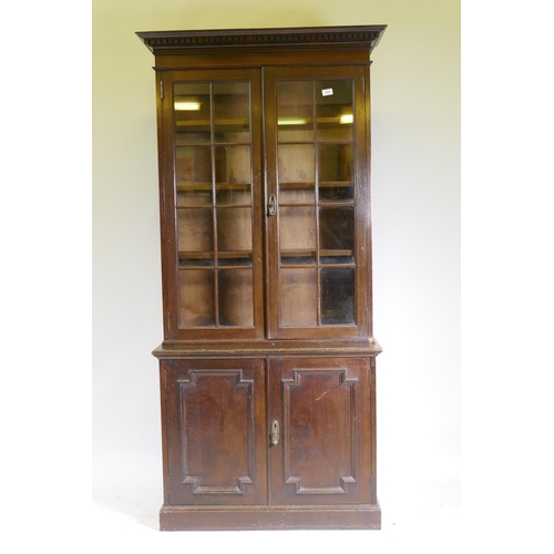 1085 - An oak bookcase, the upper section with two glazed doors, the lower two cupboards with moulded decor... 