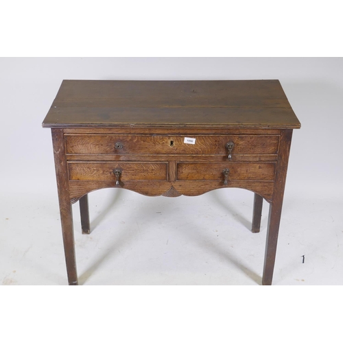 1090 - Early C19th oak side table, with single drawer over two more, shaped and carved apron and square sup... 