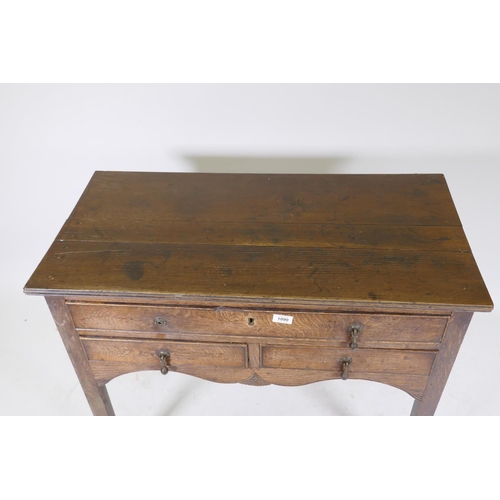 1090 - Early C19th oak side table, with single drawer over two more, shaped and carved apron and square sup... 