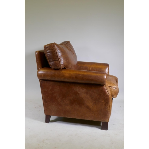 1101 - A leather club chair with brass stud detail, raised on block supports