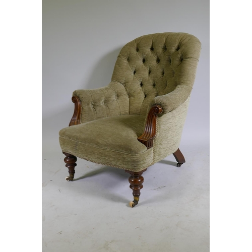 1105 - A Victorian walnut easy chair with button back and scroll arms, raised on turned supports with brass... 