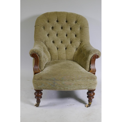 1105 - A Victorian walnut easy chair with button back and scroll arms, raised on turned supports with brass... 